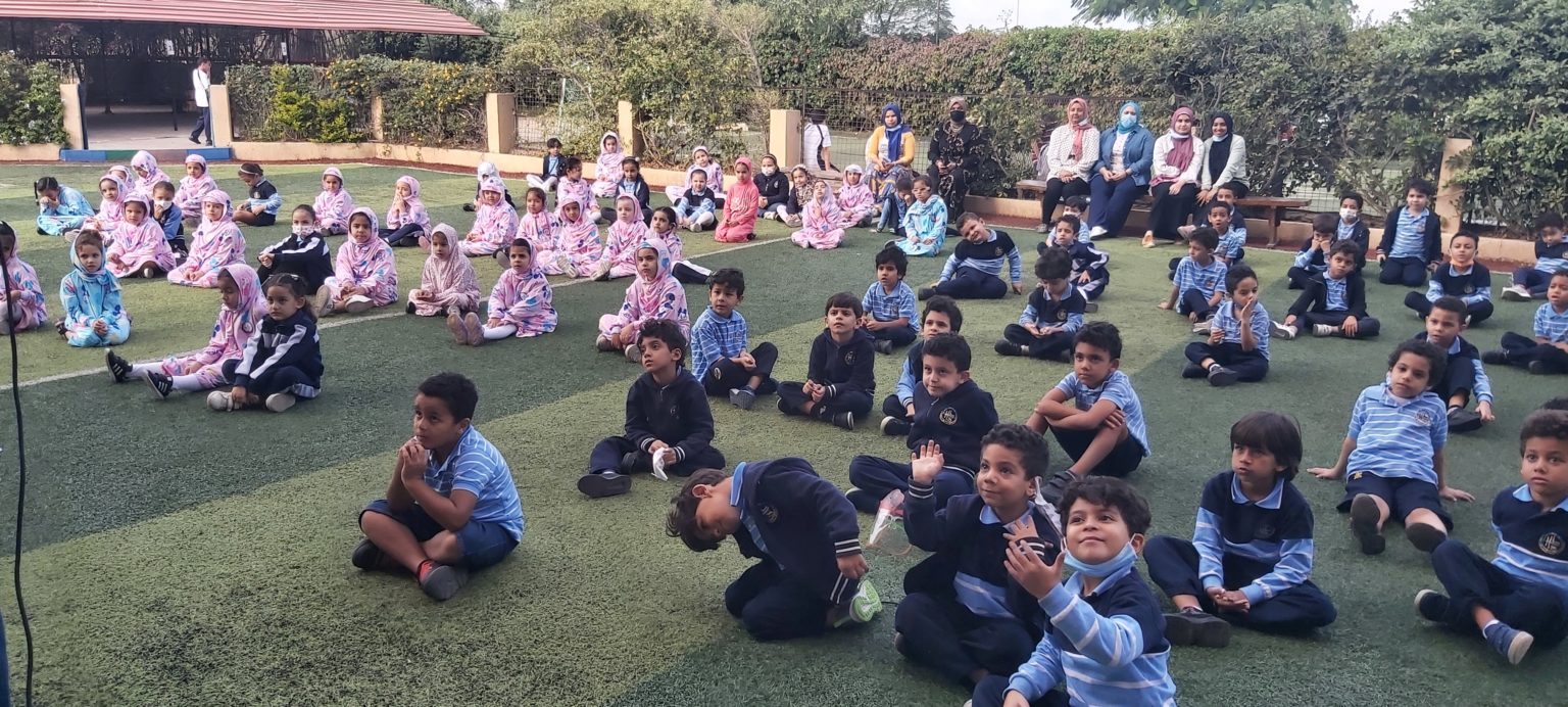 أصغر طلاب هلالية يجلسون معًا في ملعب المدرسة